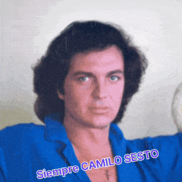 a man in a blue shirt with the words siempre camilo sesto written on the bottom