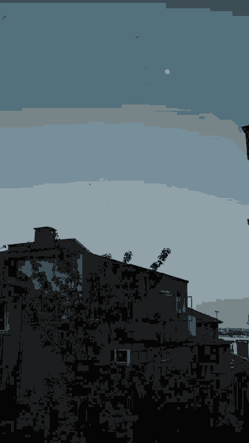 a full moon is visible in the sky above a row of buildings