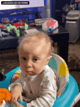 a baby is sitting in a walker with a sticker that says jjshawolo8 on perrk on it