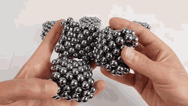 a person is holding a bunch of balls in their hands
