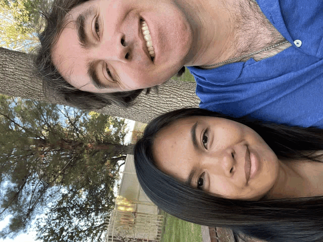 a man and a woman are posing for a picture and smiling for the camera