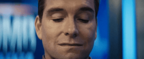 a man is making a funny face with his eyes closed .