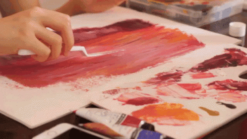 a person is painting on a canvas with a palette