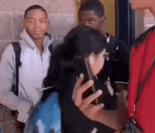 a group of young people are standing next to each other .