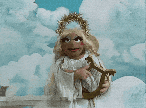 a cartoon angel is holding a harp and wearing a wreath on her head