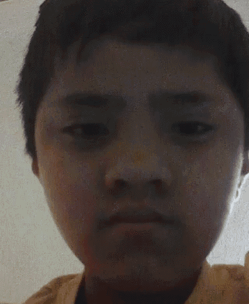 a close up of a young boy 's face with a blurred background