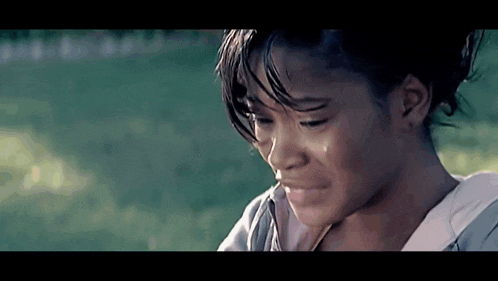 a close up of a woman 's face with a tear running down her cheek .