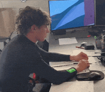 a man is sitting at a desk in front of a dell computer