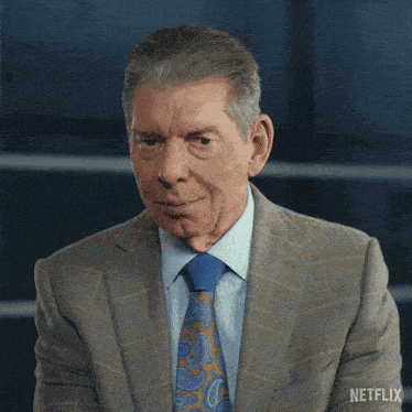 a man in a suit and tie has a netflix logo on his shoulder