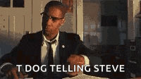 a man in a suit and tie is sitting at a desk talking to steve .