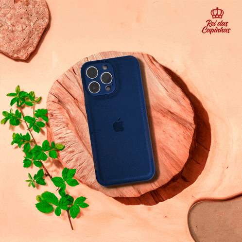 a blue iphone is sitting on a wooden block with a rei das capinhas logo behind it