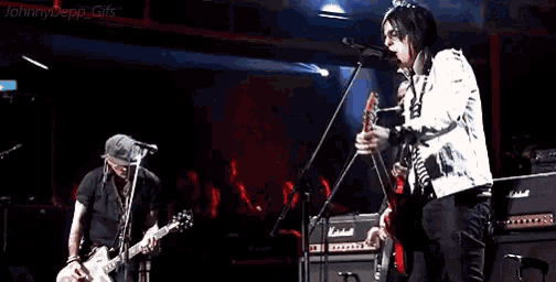 two men are playing guitars on a stage with the words johnny depp gifs at the top