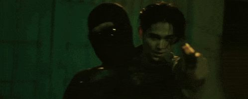 a man in a mask is pointing at another man in a mask .