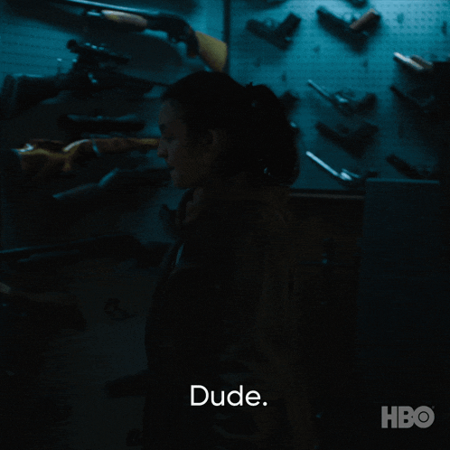 a woman is standing in front of a wall of guns and the word dude is above her