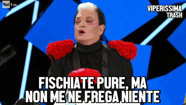 a man with red flowers on his shoulders says fischiate pure ma non me ne frega niente