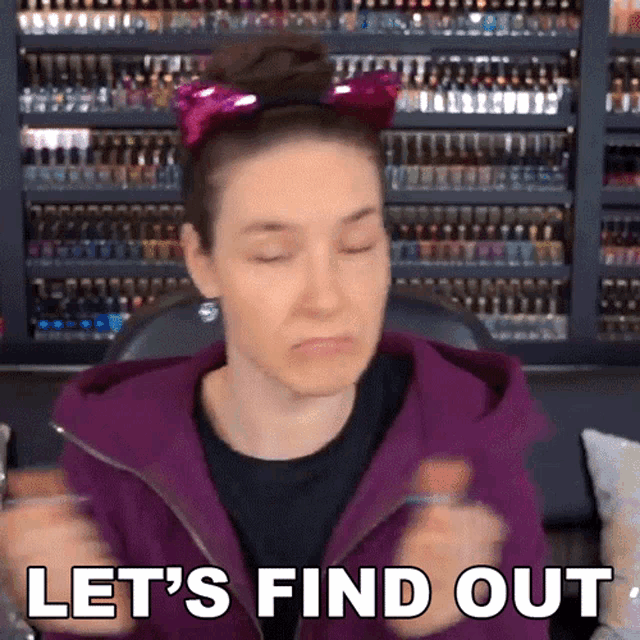 a woman wearing a pink cat ear headband says let 's find out