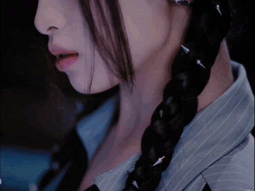 a close up of a woman 's face and braided hair