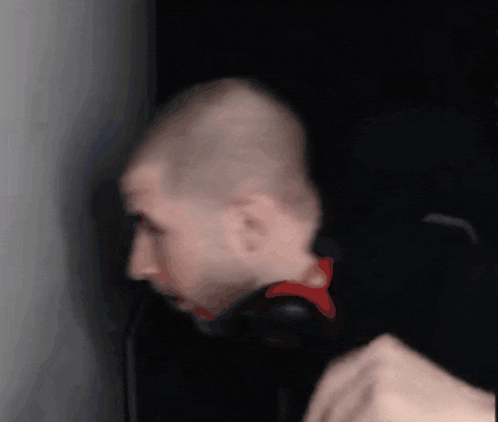 a bald man wearing headphones looks at something