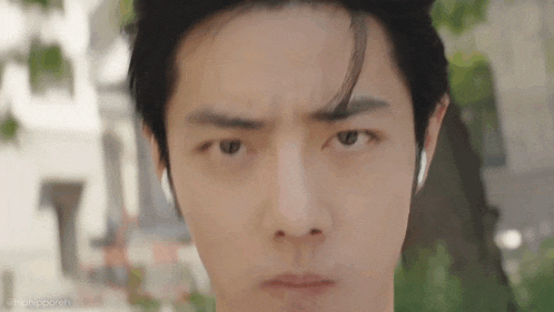 a close up of a young man 's face with a serious expression .
