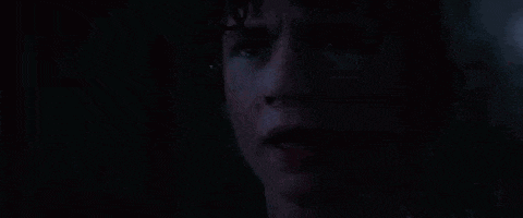 a close up of a person 's face in the dark with tears coming out of his eyes .