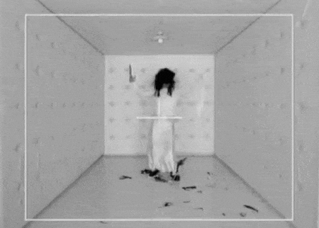 a black and white photo of a woman in a white dress holding a knife