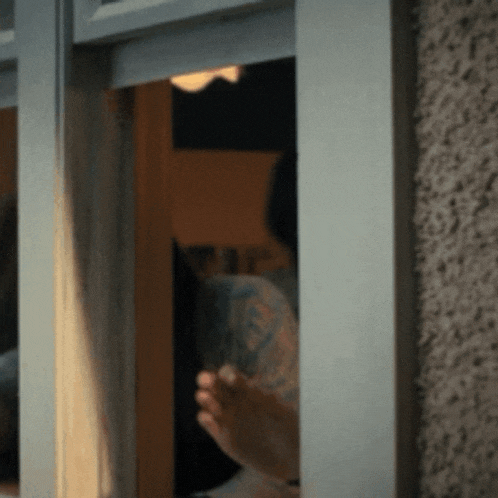 a person 's feet are sticking out of a window frame .