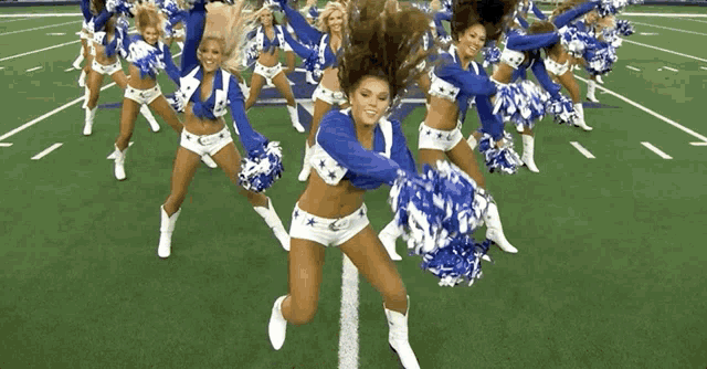 a bunch of cheerleaders are dancing on a field