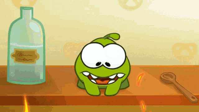 a green cartoon character is sitting on a table next to a bottle of water and a spoon