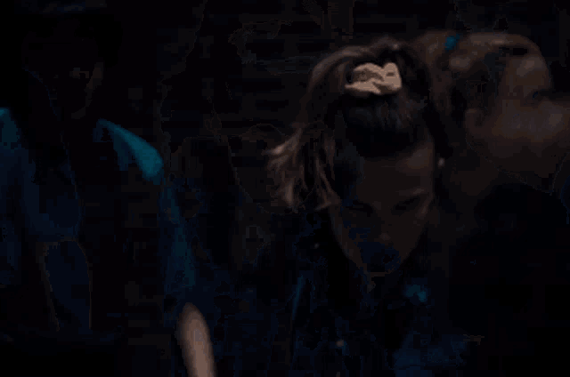 a group of people are standing next to each other in a dark room and looking at the camera .