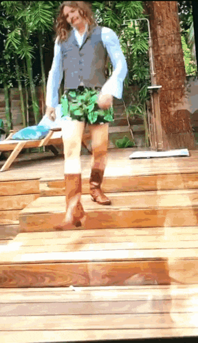 a man in a vest and shorts is walking down a set of stairs