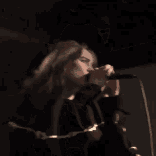 a woman is singing into a microphone on stage