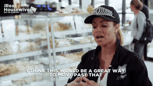 a woman wearing a hat and a jacket says " i think this would be a great way to move past that "