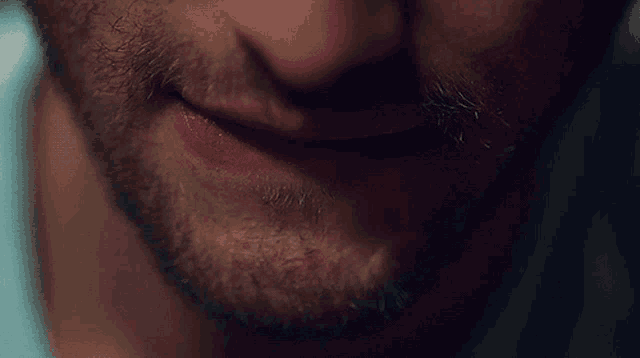 a close up of a man 's face with a beard and red lips