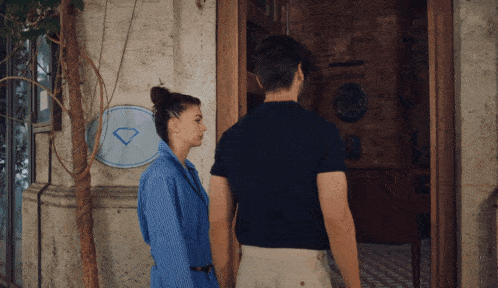 a man and woman are standing in front of a building with a sign that says diamond on it