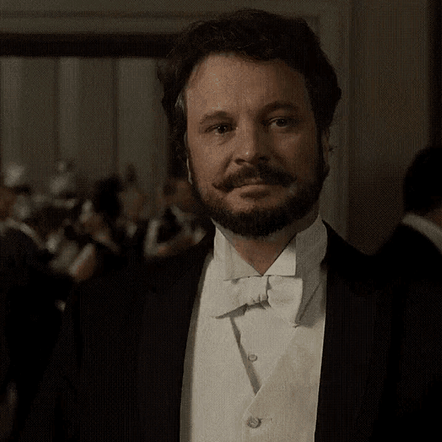 a man with a beard wearing a tuxedo and a white vest