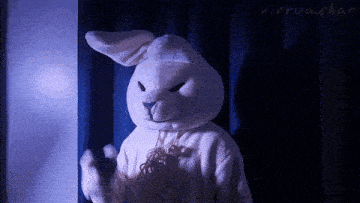 a white stuffed bunny is standing in front of a blue curtain with virtua.chat written on it