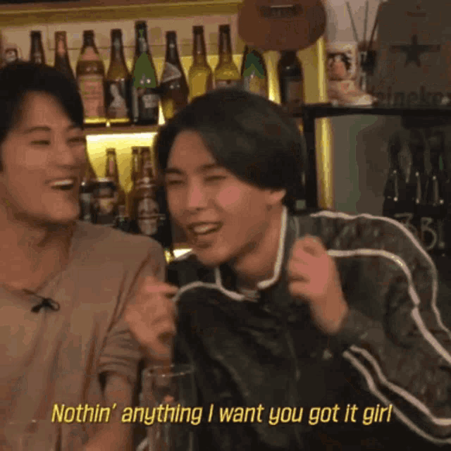 a man is laughing in front of a shelf full of beer bottles and says exclusive