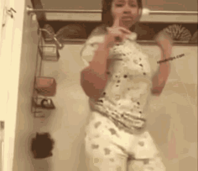 a woman is standing in a bathroom taking a picture of herself .