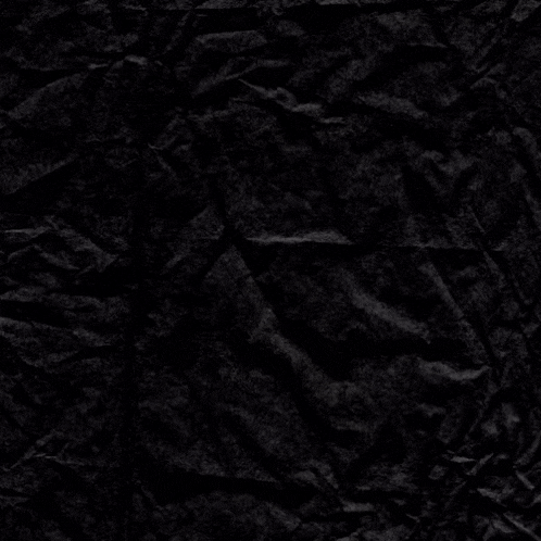 a piece of crumpled black paper with a white cross on it