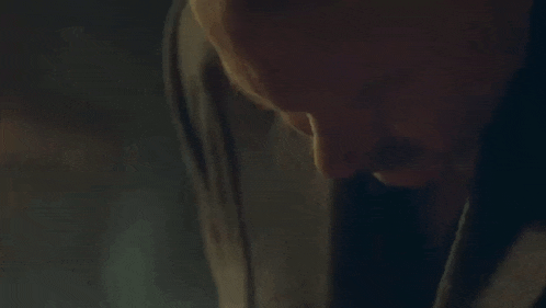 a close up of a man 's face with a mustache in a dark room .