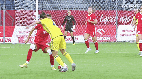 a soccer game is being played in front of a tvp sport sign