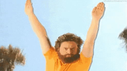 a man with a beard is jumping in the air with his arms in the air and the words #winning behind him