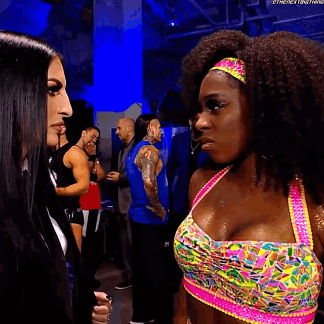 a woman in a colorful top is standing next to another woman
