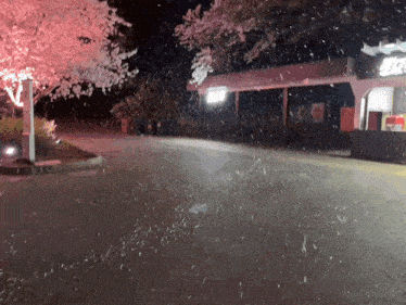 a building with a sign that says ' coca cola ' on it is lit up at night