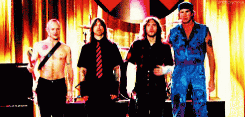a group of men standing next to each other in front of a red curtain with the word fame on the bottom left