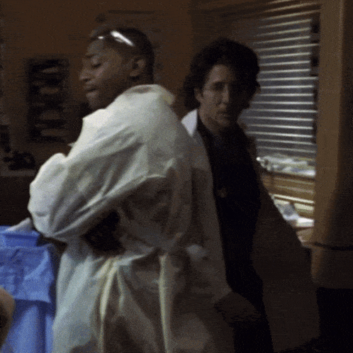 a man in a lab coat stands next to a woman