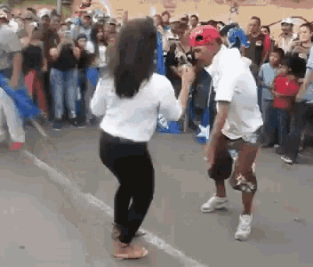 a man and woman are dancing in front of a crowd of people
