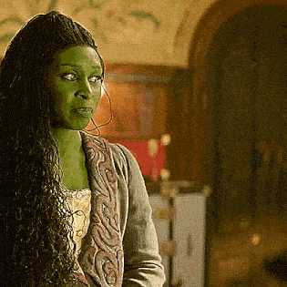 a woman with long green hair is standing in a room .