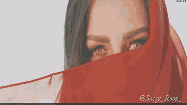 a close up of a woman 's face with a red cloth covering her face