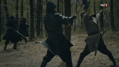 a group of people are standing around a man with a sword in his hand .